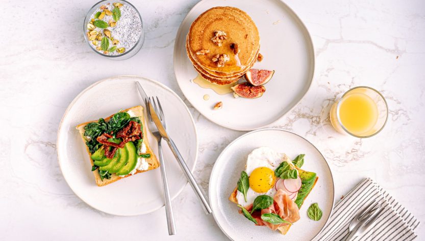 Aerial view of a delicious and healthy breakfast with pancakes, avocado toast, and refreshing drinks. — Bulk discounts availa