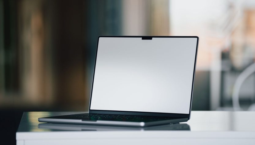A sleek, modern laptop positioned on a desk with a blurred background.