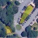 Aerial view of a parking lot outlined with color-coded sections and surrounded by trees.